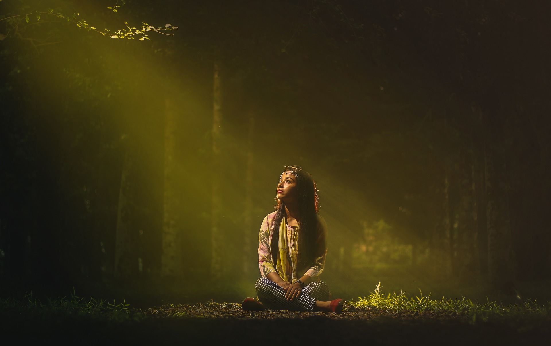 Woman looking up into a stream of light